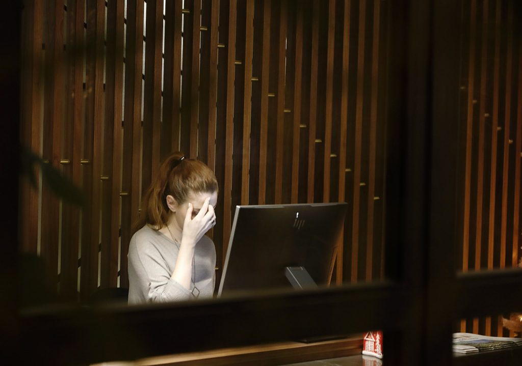 a woman sitting in front of a laptop computer