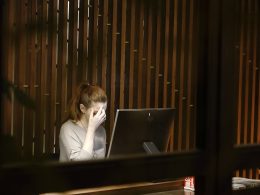 a woman sitting in front of a laptop computer