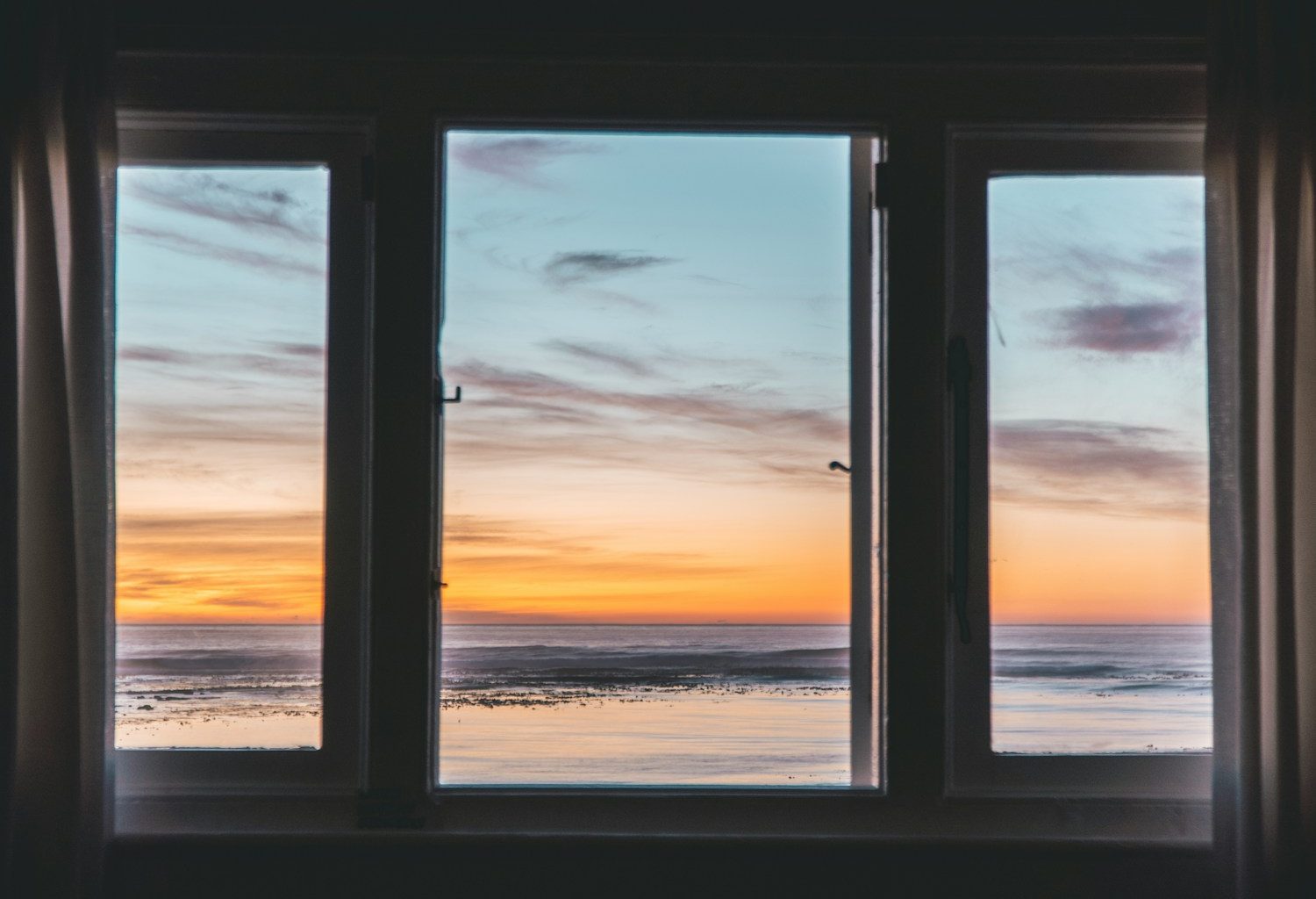 white wooden framed glass window near body of water