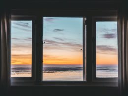 white wooden framed glass window near body of water