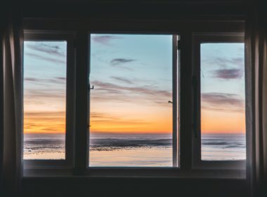 white wooden framed glass window near body of water