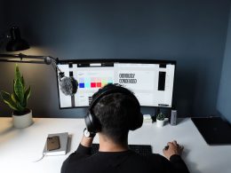 man in black shirt sitting in front of computer