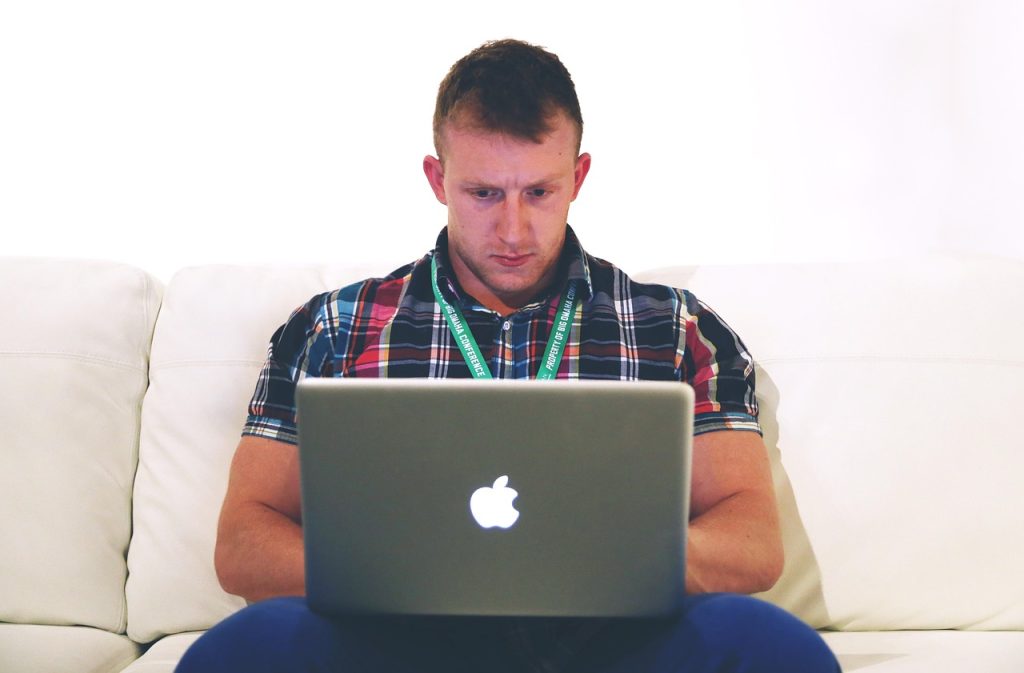 Persoon die 's avonds thuis werkt aan laptop als bijverdienste naast vaste baan