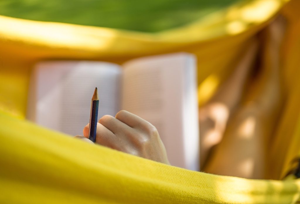 Persoon die ontspannen in een hangmat ligt tijdens de zomervakantie
